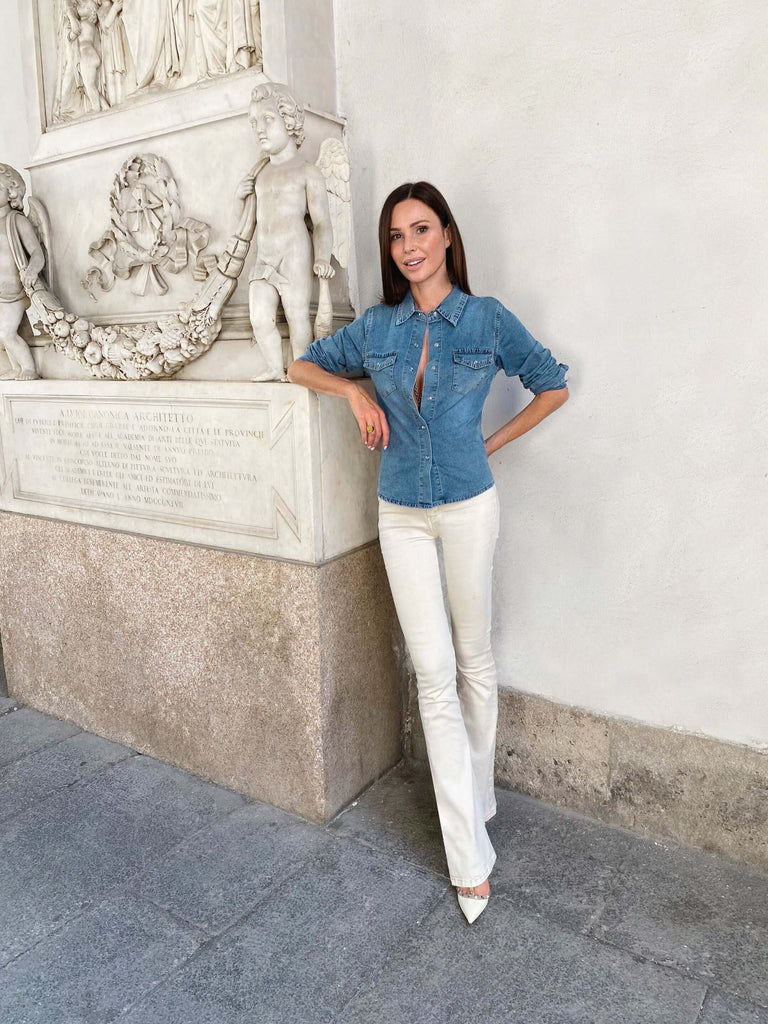 accademia di brera a Milano, la stilista italiana Celeste Pisenti posa vicino alla scultura del Canova e indossa jeans bianco  modello Jane e camicia in denim.